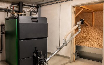 Pelletkessel im Keller, daneben das über eine Förderschnecke angebundene Pelletlager.